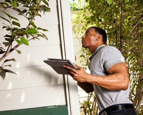 An inspector looking at a home's exterior